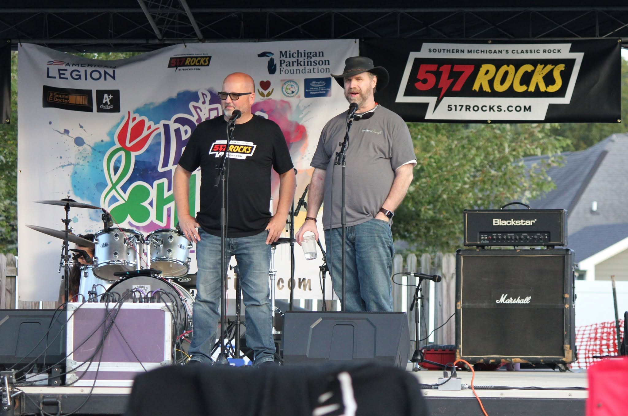 Two men at microphones on the Irish Hills Festival stage